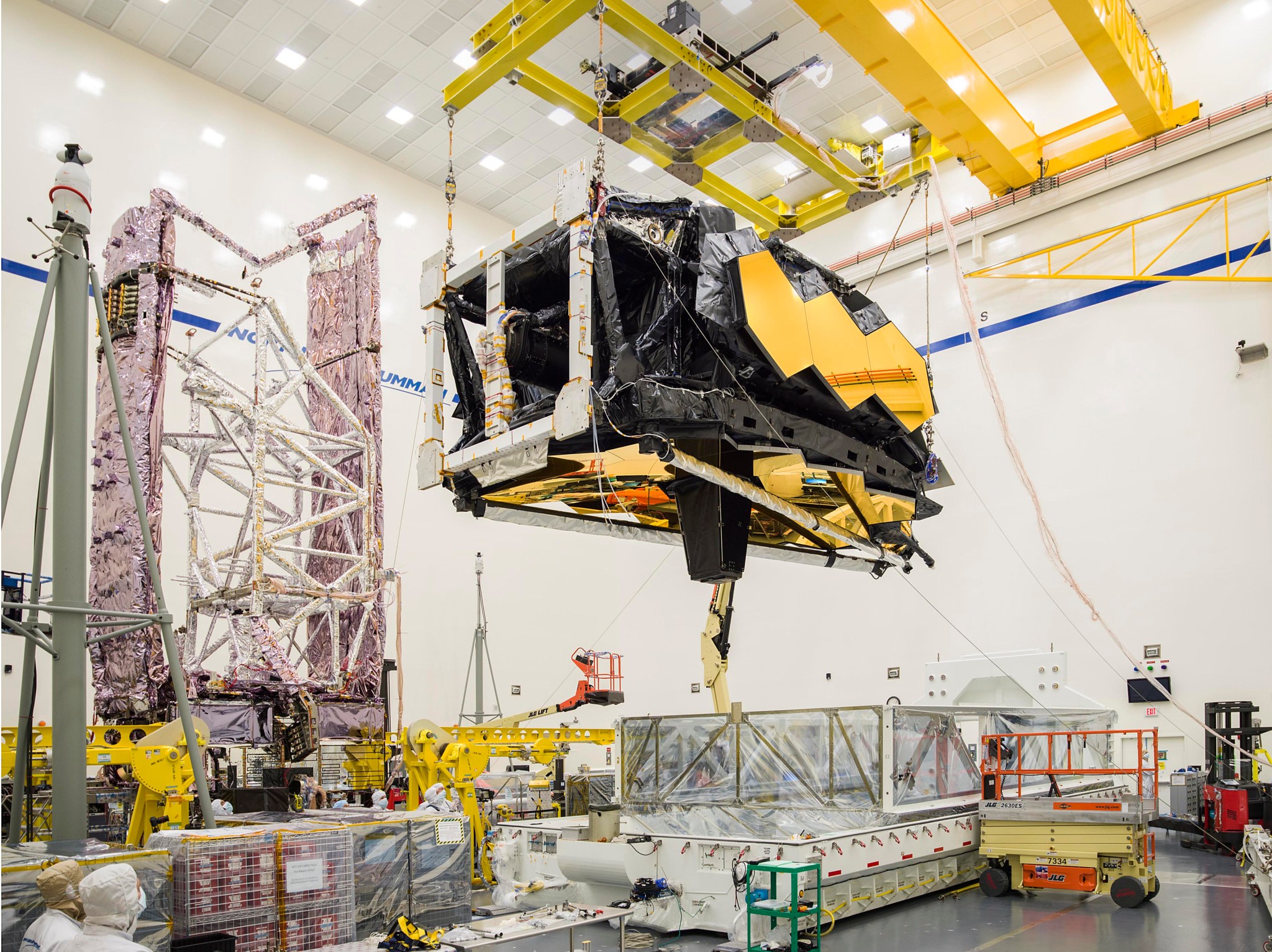 Engineers lift the combined optics and science instruments of NASA’s James Webb Space Telescope