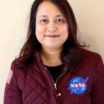 Photo of Nasseem Rangwala in a burgundy jacket with a blue NASA logo. 