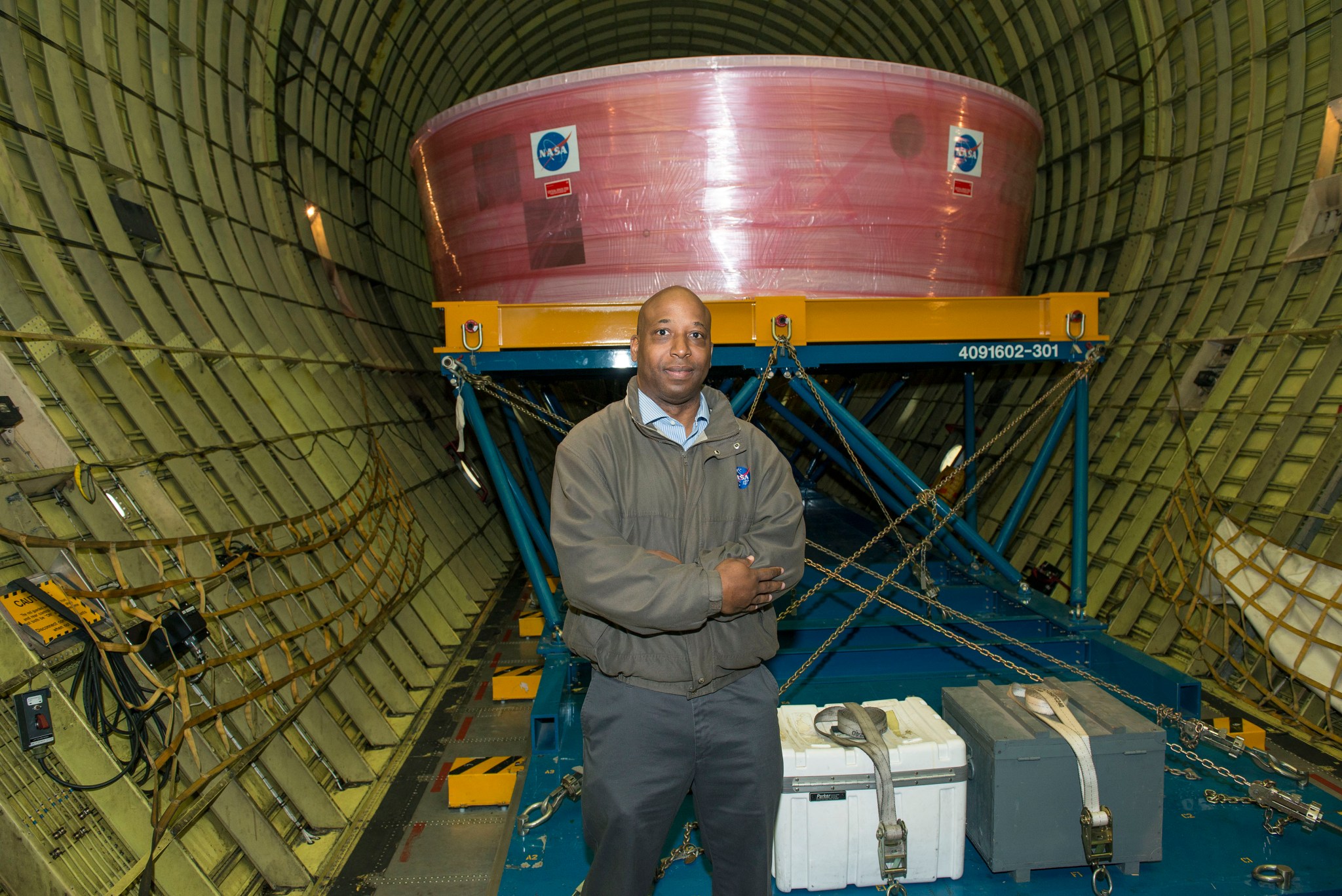 Maasha stands in front of the Orion stage adapter in the cargo hold of NASA's Super Guppy aircraft. 