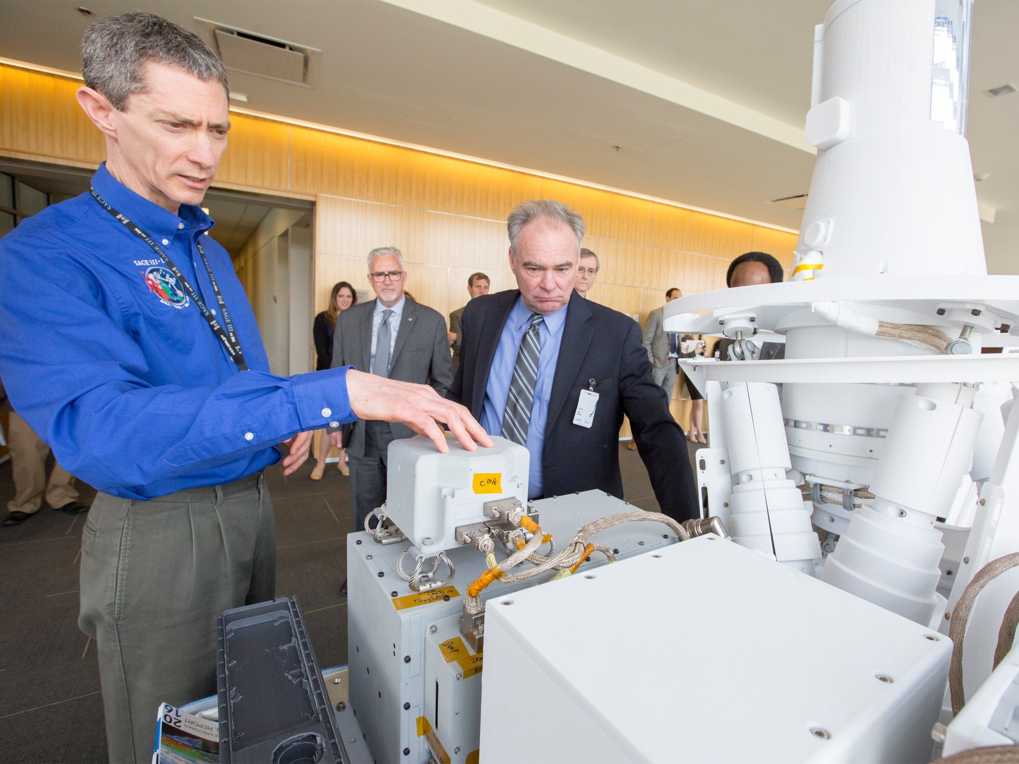 NASA Scientist Dave Flittner, left, shows U.S. Sen. Tim Kaine a model of the Stratospheric Aerosol and Gas Experiment III.