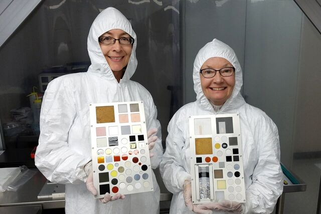 technicians pose with their MISSE-9 experiment samples integrated into MISSE sample carrier decks.