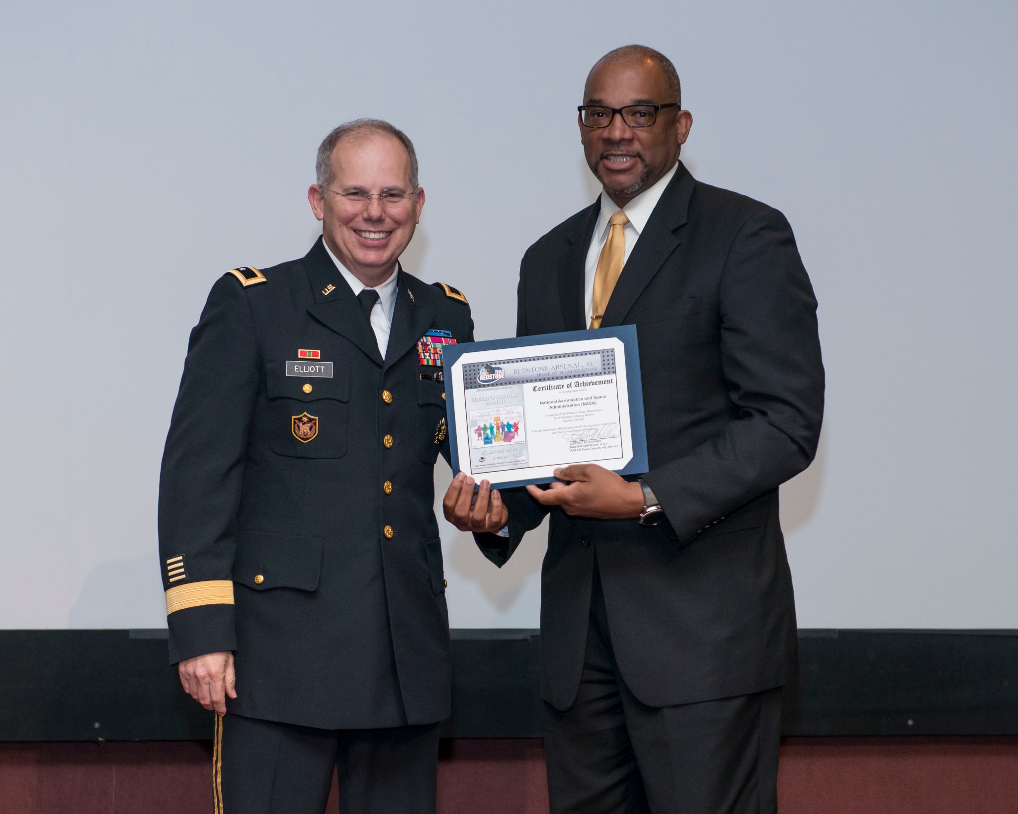 Loucious Hires accepts an award from Maj. Gen. Allan Elliott on behalf of the center.