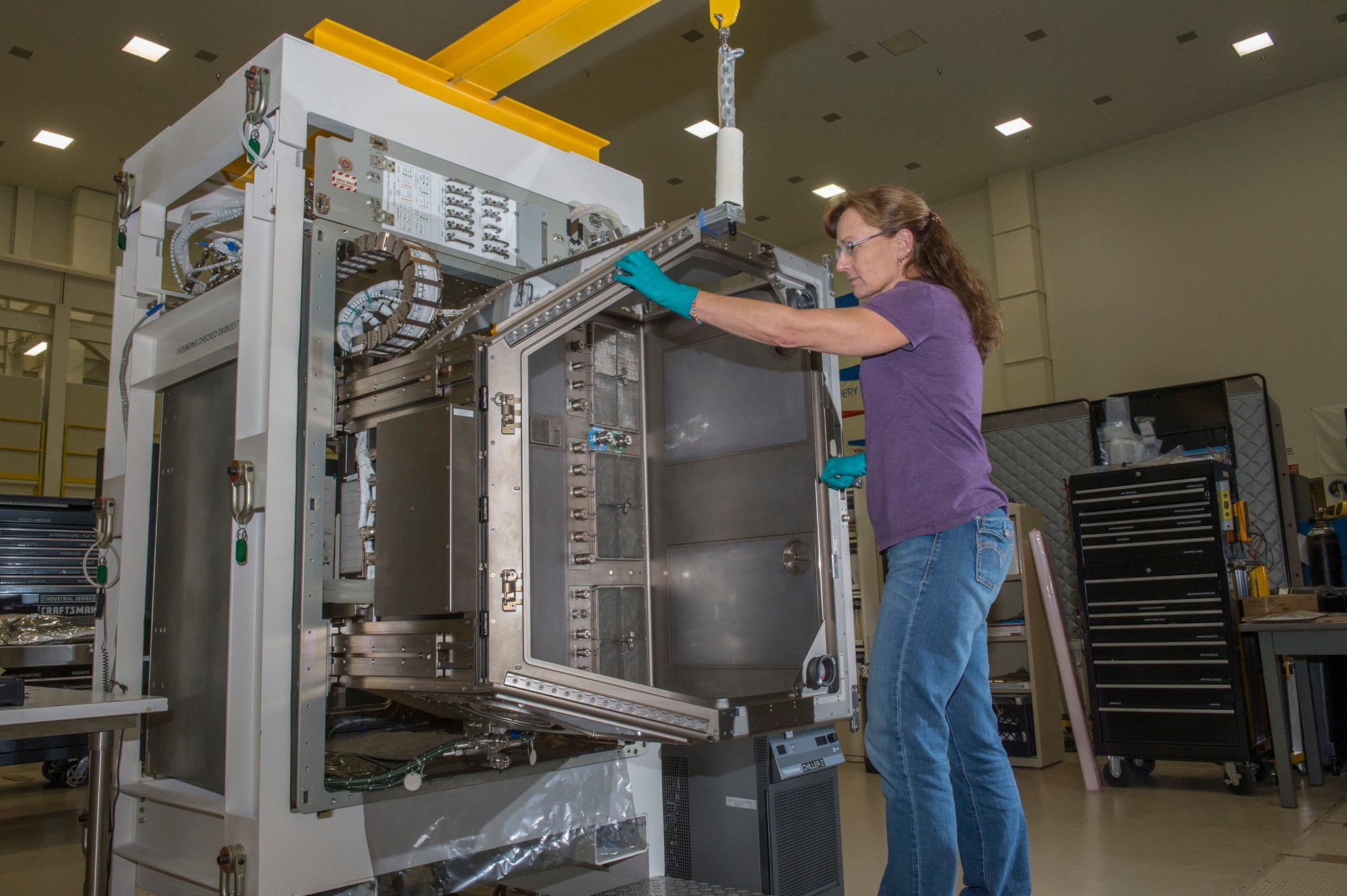 Karen Whitson demonstrates how the new Life Sciences Glovebox slots into the storage rack that will house it aboard the ISS.
