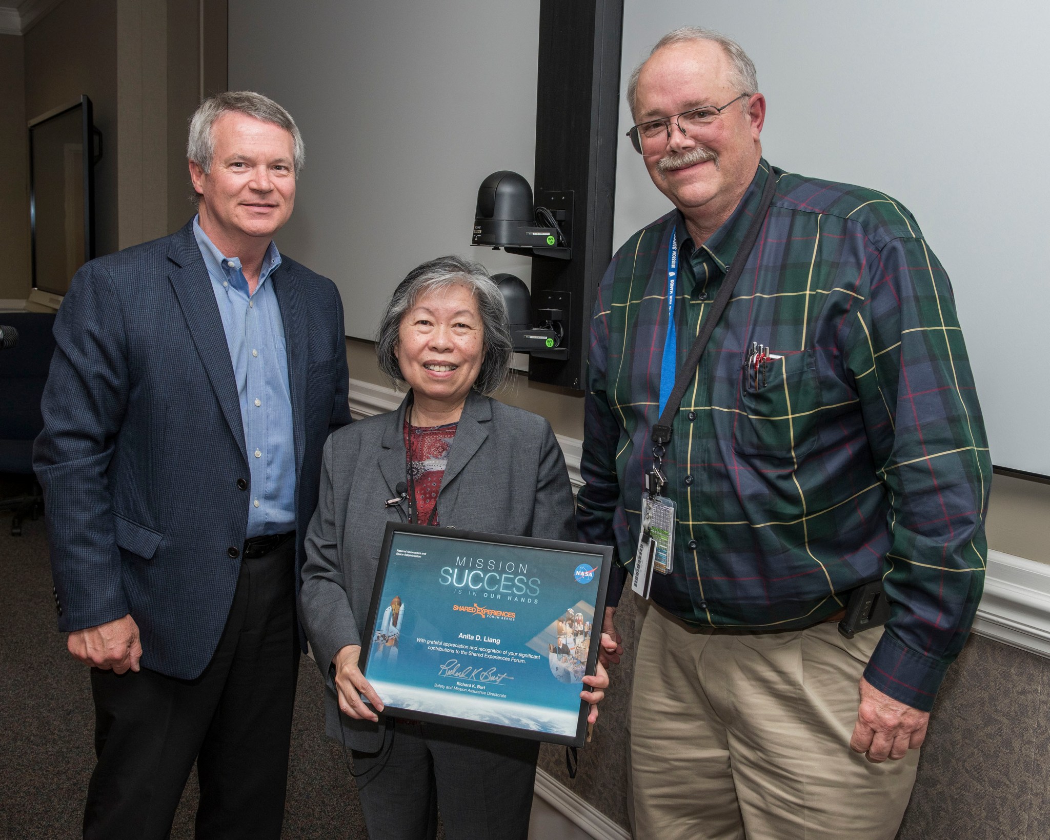 Anita Laing receives a certificate of appreciation and recognition from Rick Burt, right, and Randy Lycans.