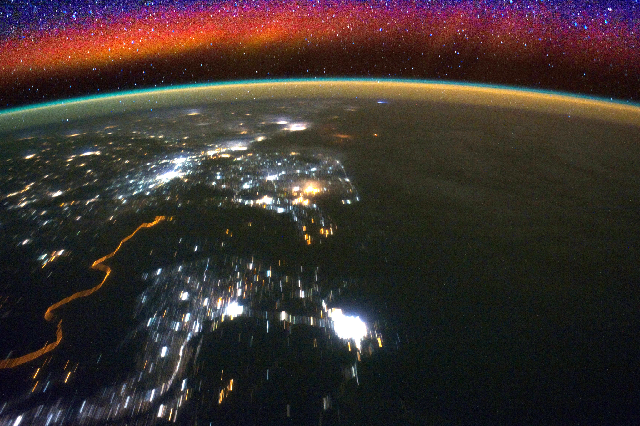 Processes in Earth’s ionosphere create bright swaths of color in the sky, known as airglow, as seen here in an image.