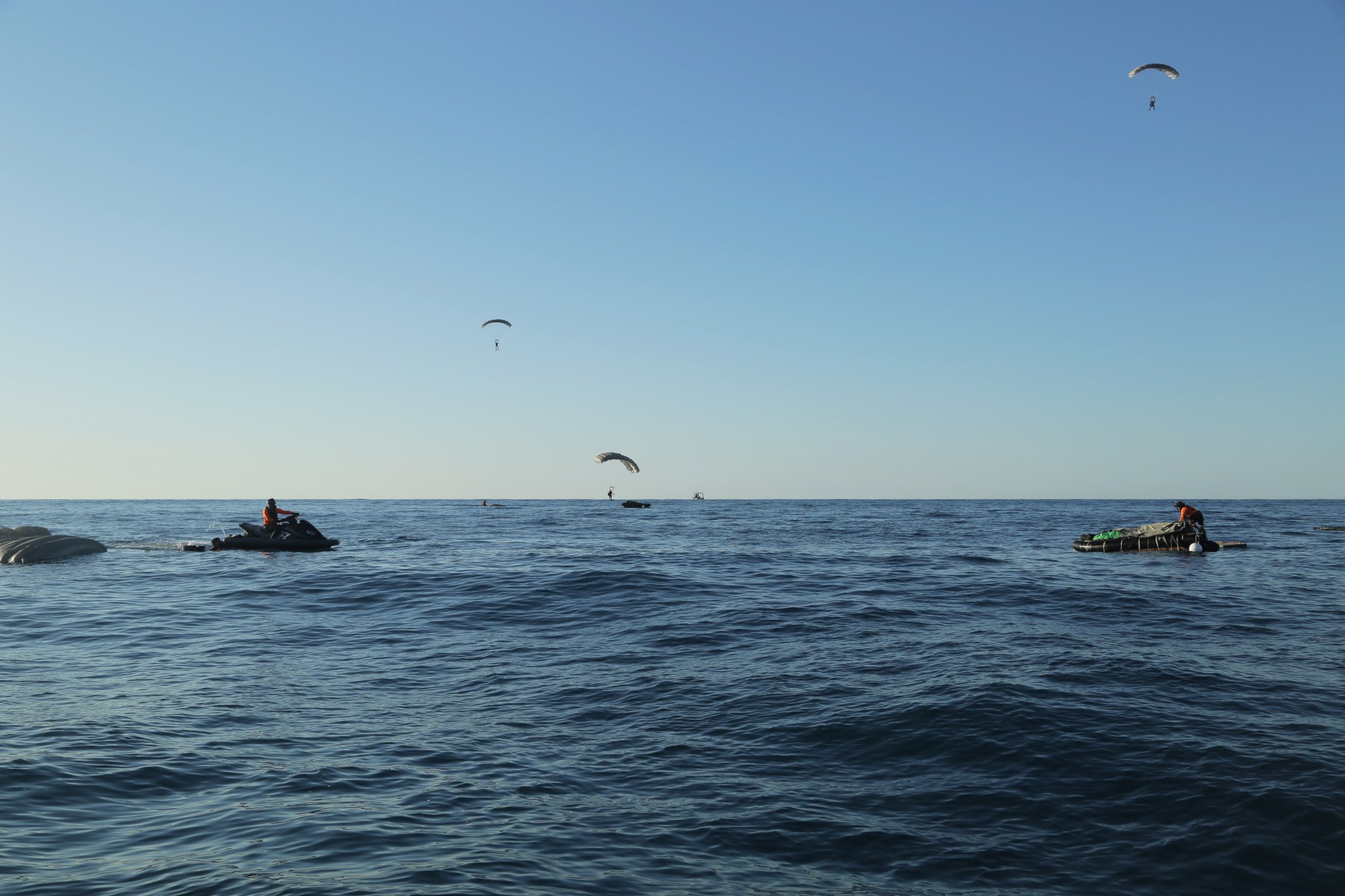 Pararescue specialists deploy their parachutes and prepare to touch down on the Atlantic Ocean surface during an astronaut rescue training exercise in April.