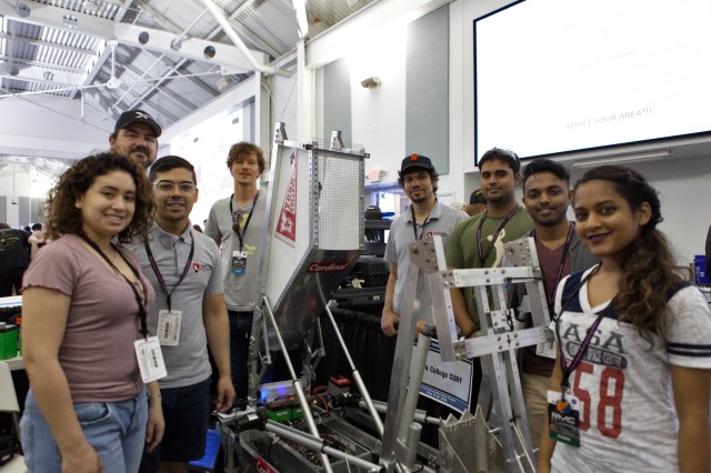 A group of students standing around a lunabotic