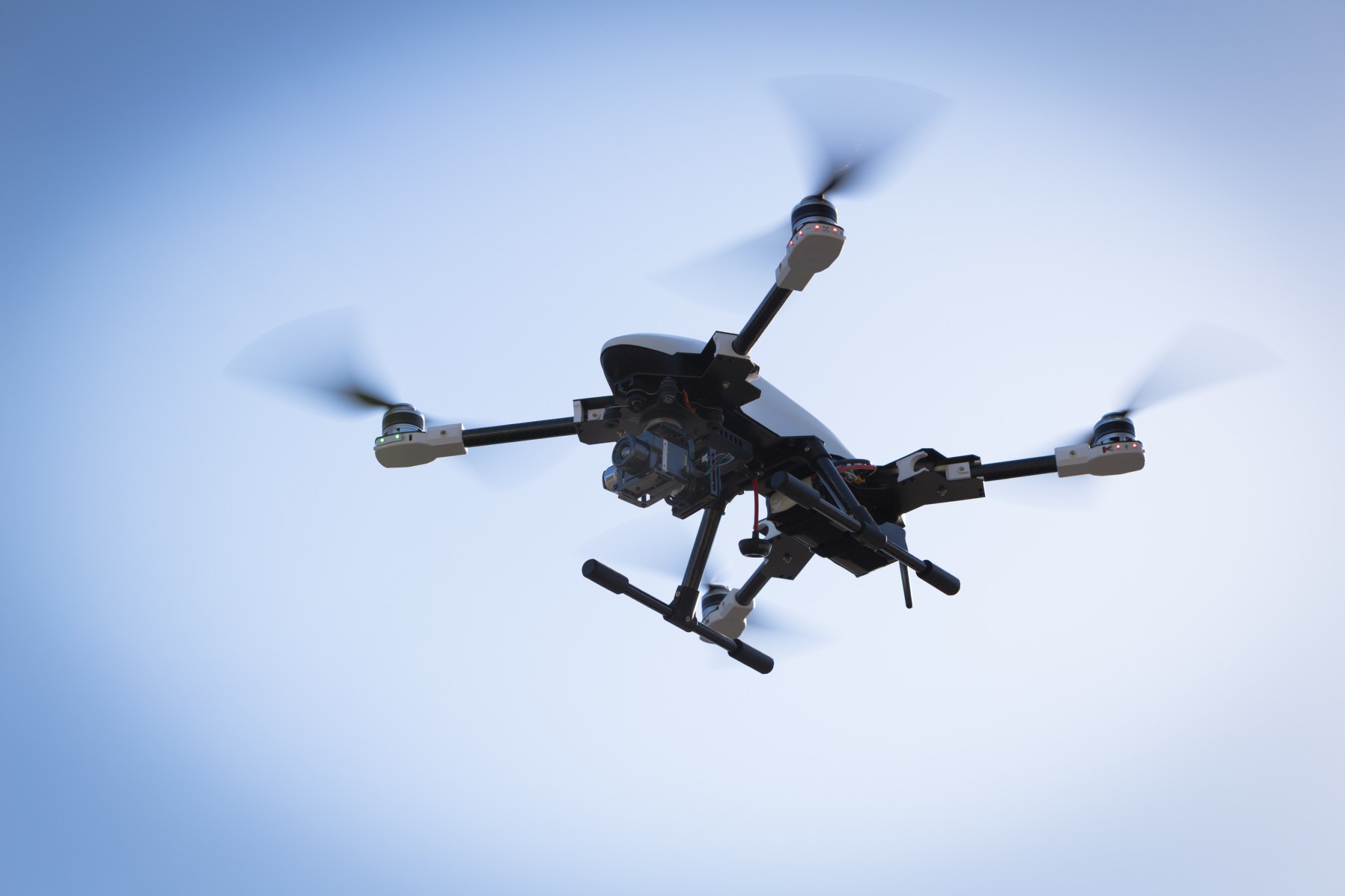 View of a drone from the ground flying in the sky.