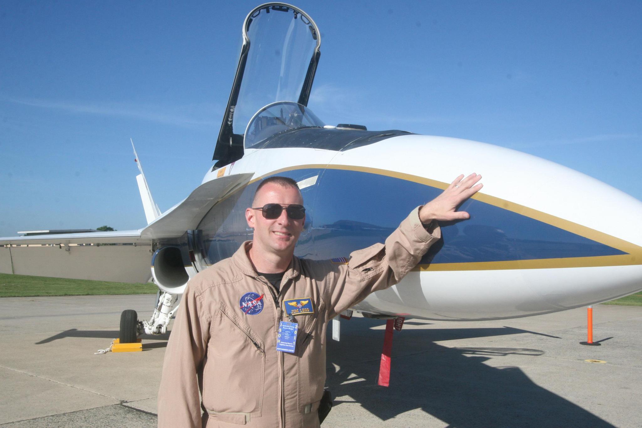 Jim Less, a NASA pilot standing next to an aircraft.
