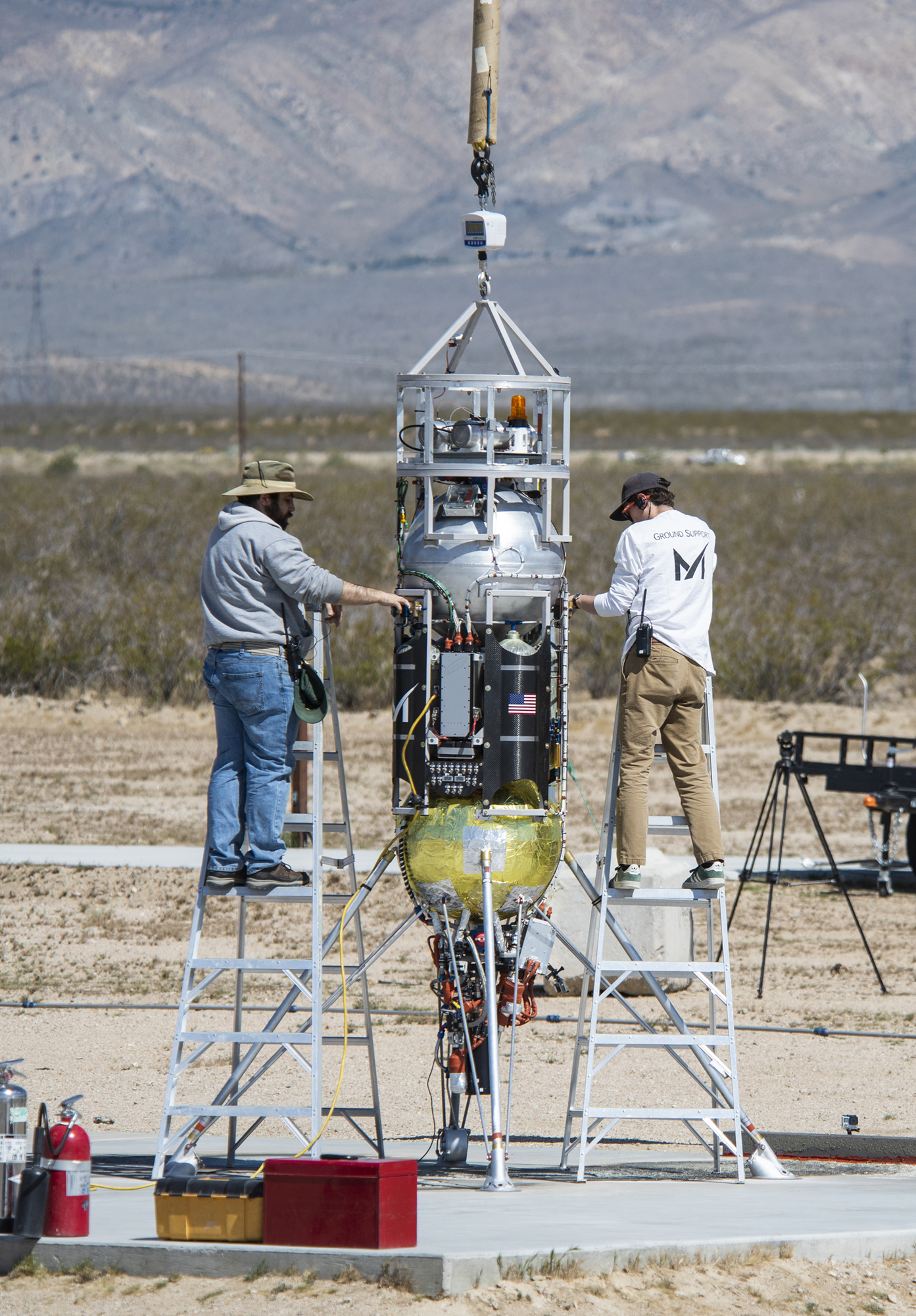 Masten technicians prepare their Xodiac rocket to flight test Honeybee Robotics pneumatic sampler collection system, PlanetVac.