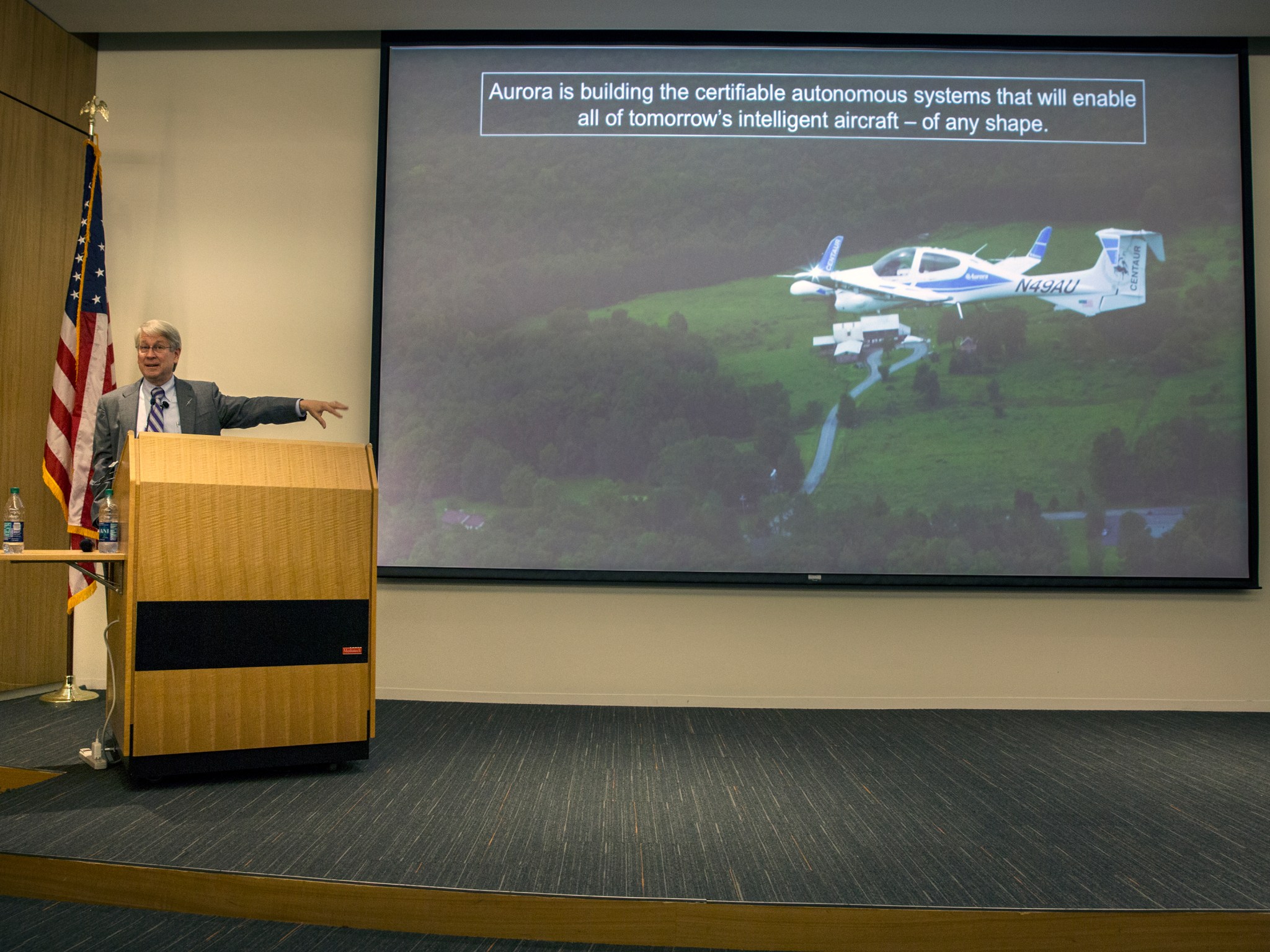 John Langford points to an image of Aurora's Centaur optionally piloted aircraft.