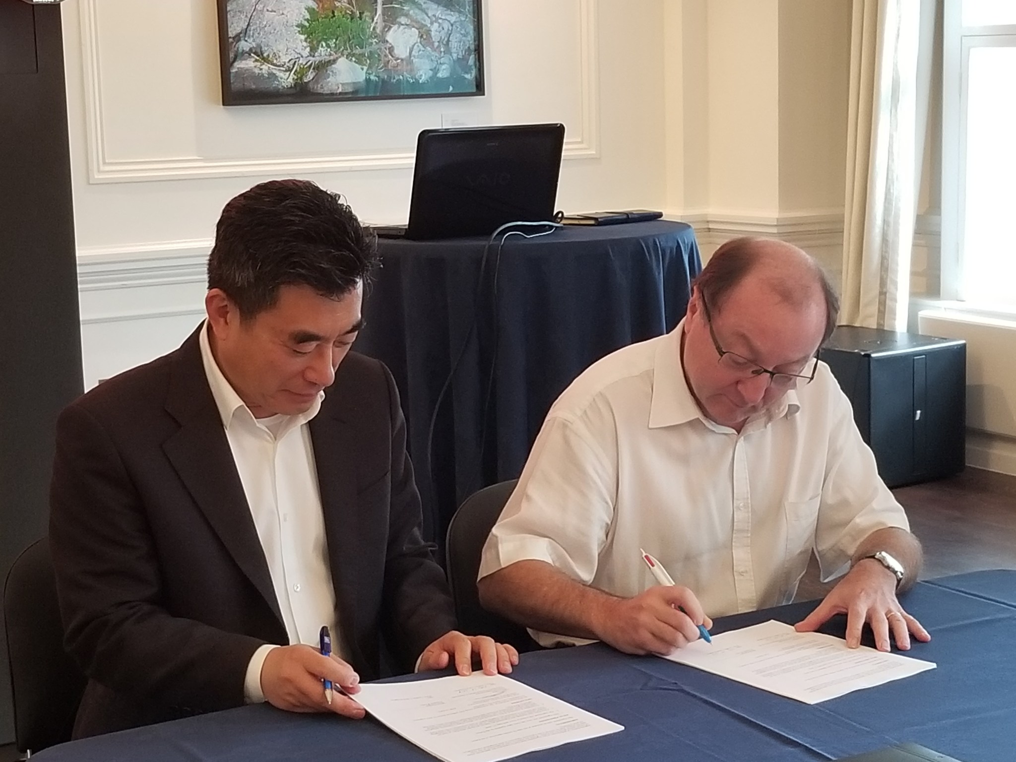 Dr. Jaiwon Shin of NASA (left) and Bruno Saigon of ONERA sign an agreement in London
