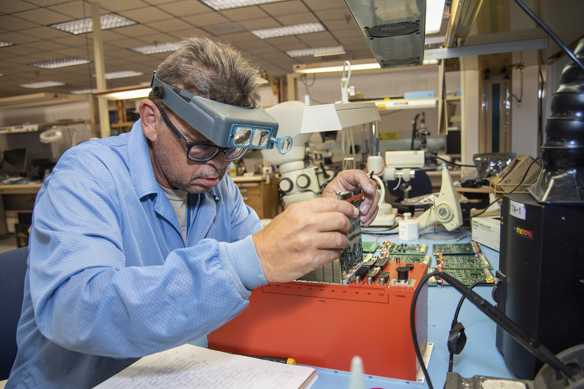 Randy Wagner prepares elements of the Orion Ascent Abort 2 crew module backup data acquisition system for thermal testing.