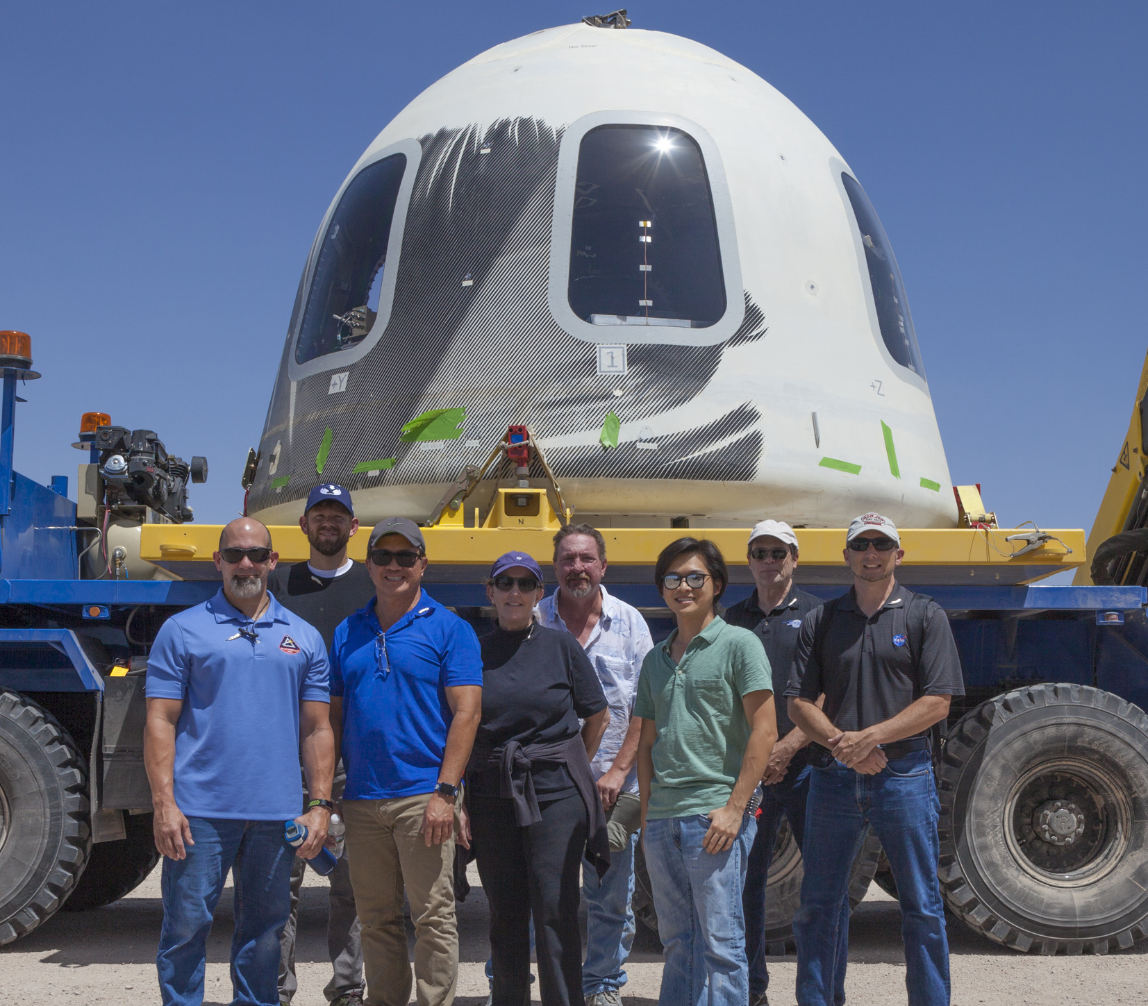 NASA SFEM-2 team poses in front of the Blue Origin capsule after a successful launch and landing.
