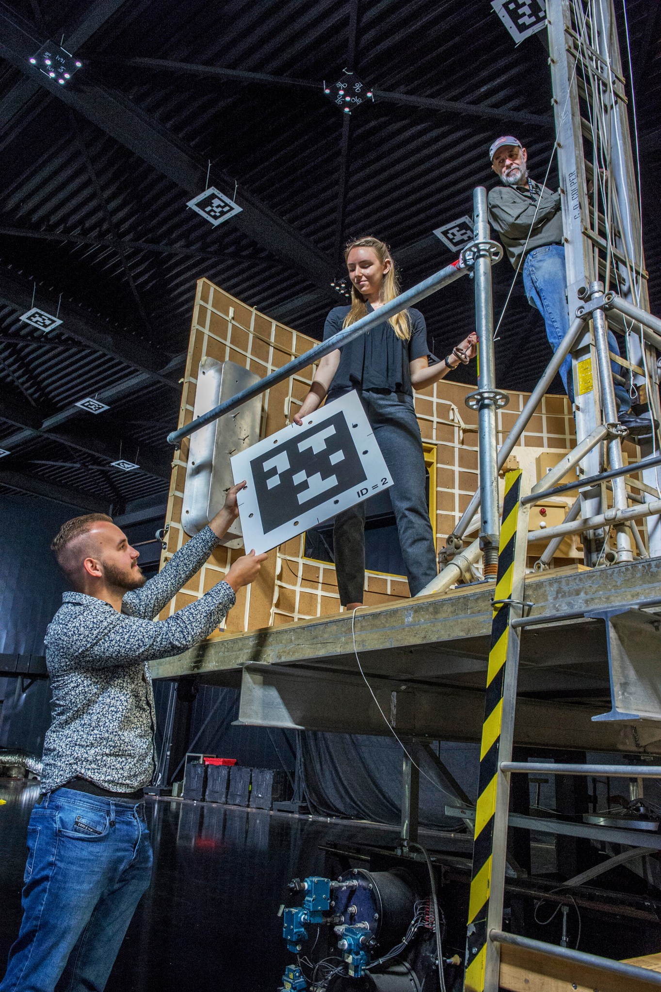 Engineering interns Tristan Schuler, left, and Greta Studier, center, along with their mentor Tom Bryan, install 2D barcodes.