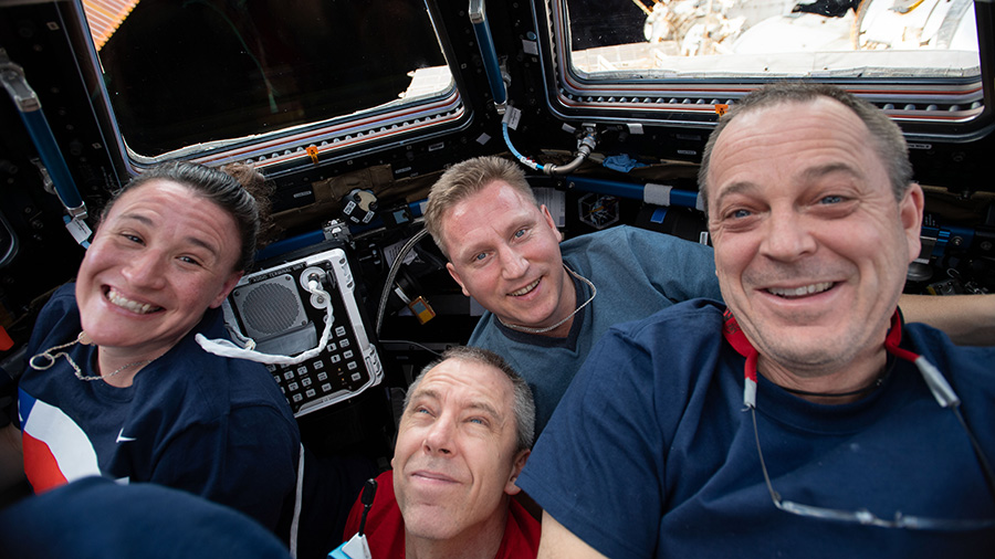 Four Expedition 56 crew members gather inside the Cupola