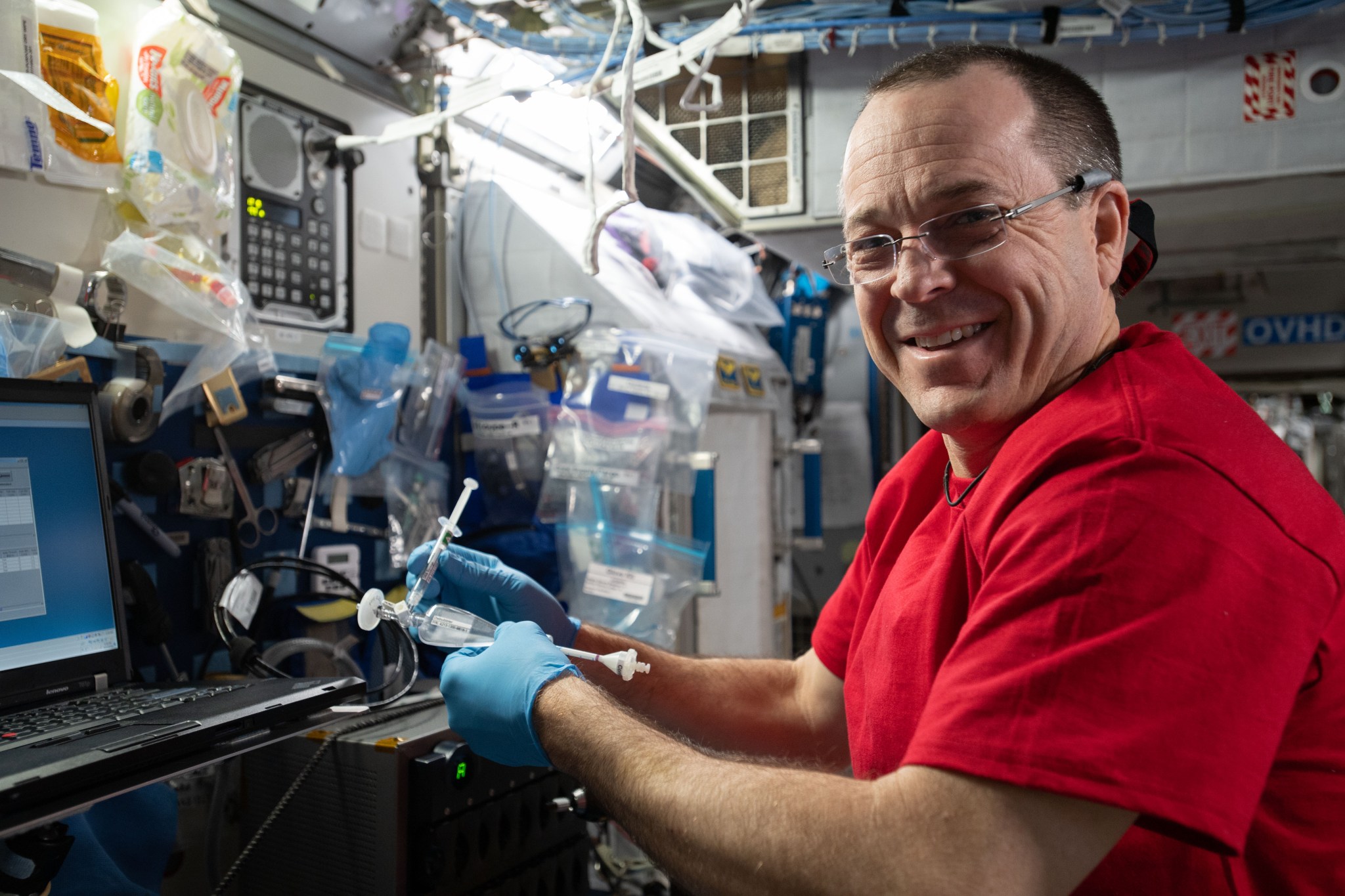 Astronaut Ricky Arnold works to extract RNA from biological samples