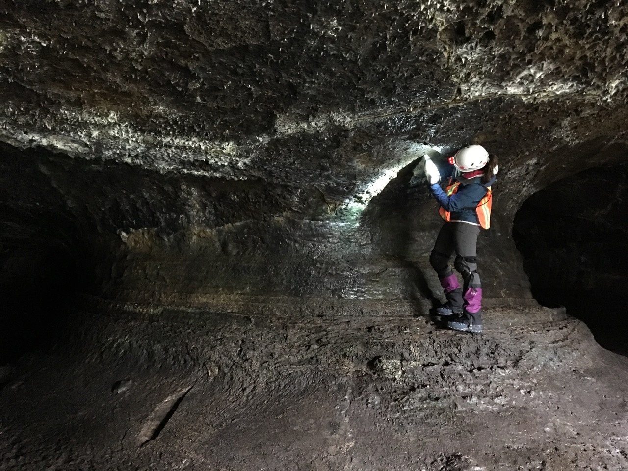 A NASA geologist testing an instrument in a cave.