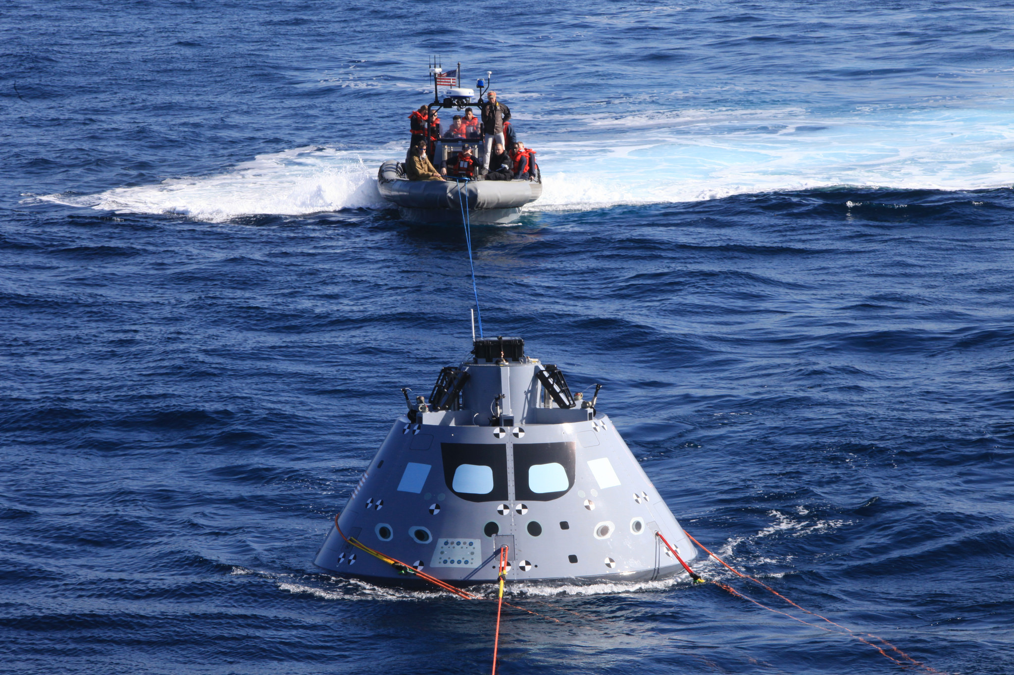 NASA’s Recovery Team and the U.S. Navy pull the Orion test capsule with a line in the Pacific Ocean