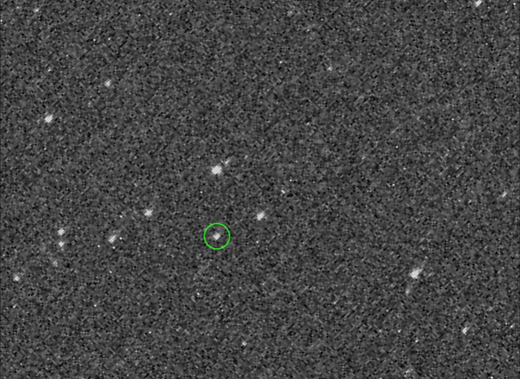 Very pixelated image of asteroids with Asteroid Bennu circled in green. 