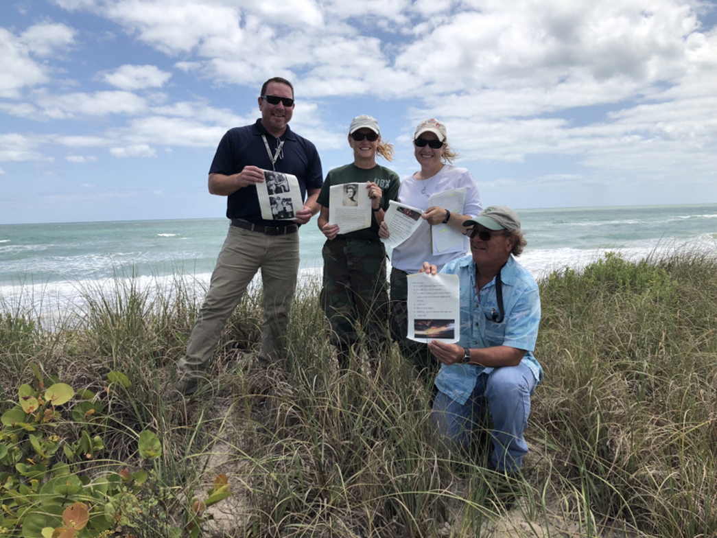 Kennedy Space Center ecology team members hold pages of a message they found in a bottle during a site survey.