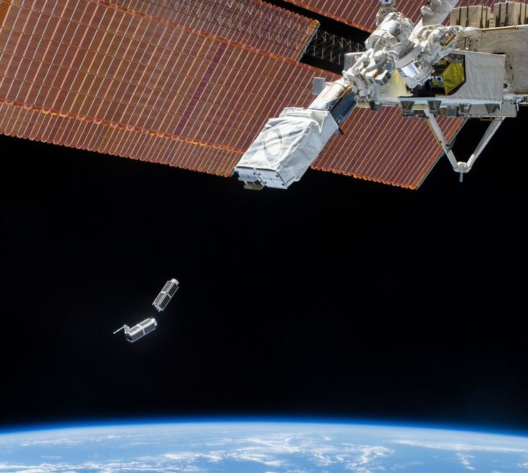 Two Dove small satellites shown deploying from the International Space Station.