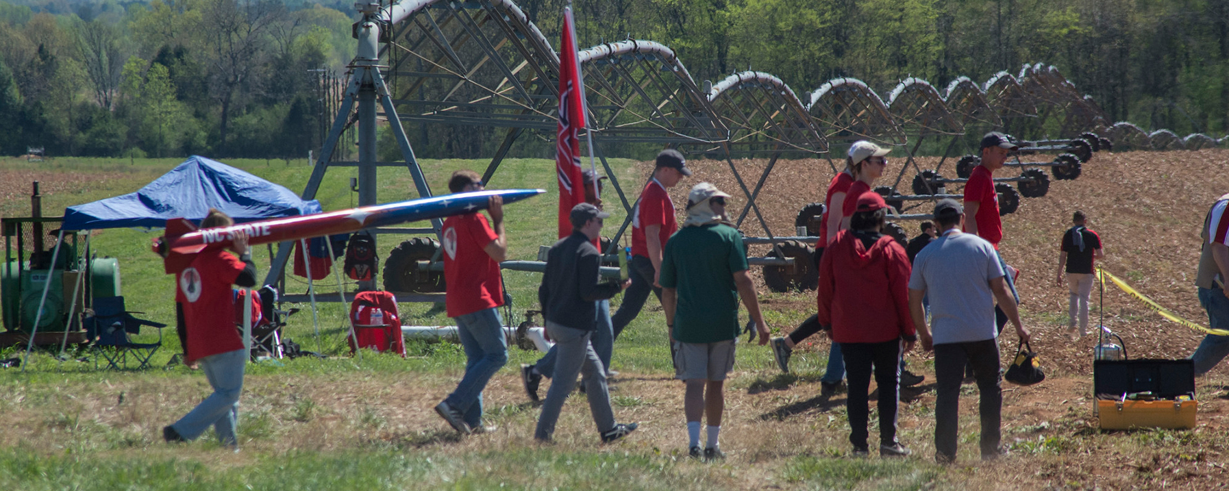 People in field with a rocket