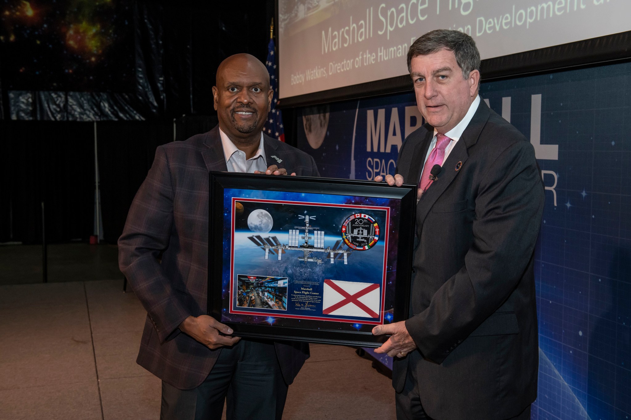 Kirk Shireman, right, presents a plaque to Bobby Watkins at the Nov. 1 all-hands meeting with space station personnel.