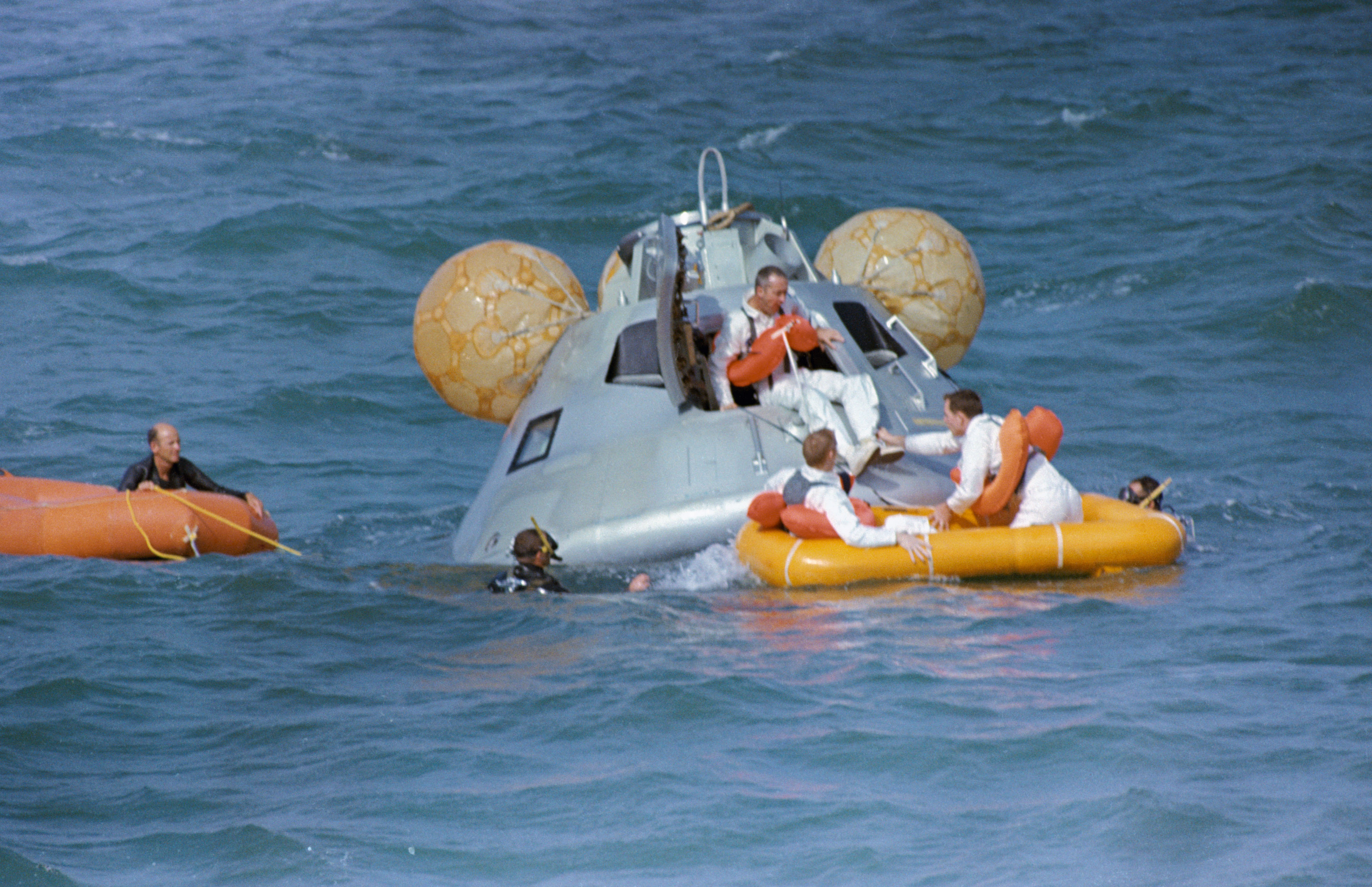 :  McDivitt (emerging from capsule), Schwieckart (left in raft), and Scott (right in raft) complete water egress training in the Gulf of Mexico