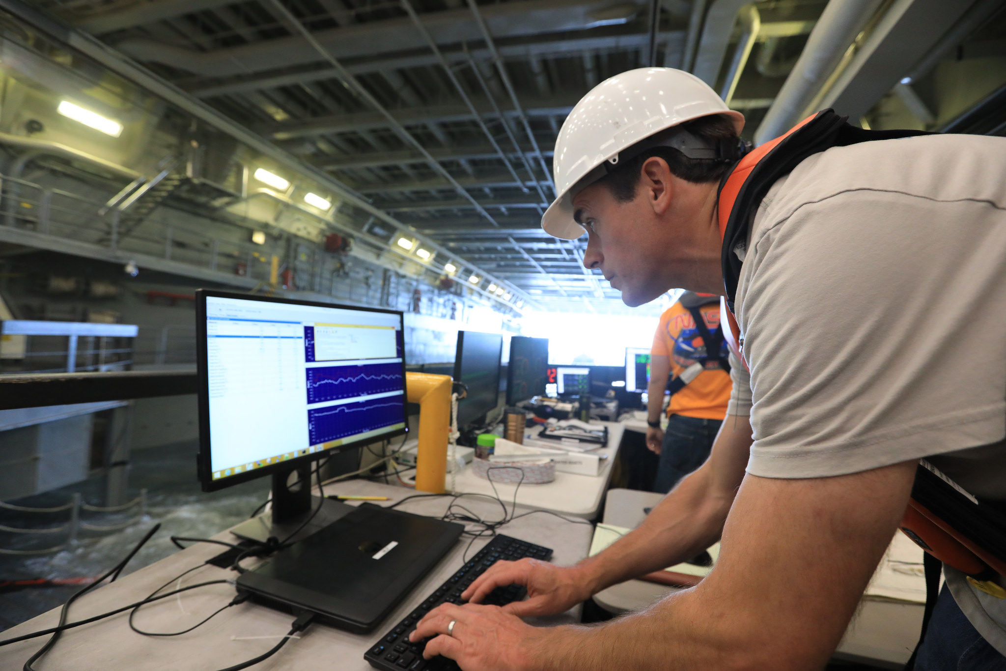 Benjamin Connell, with Applied Physical Sciences, monitors wave movement inside the well deck of a U.S. Navy ship.