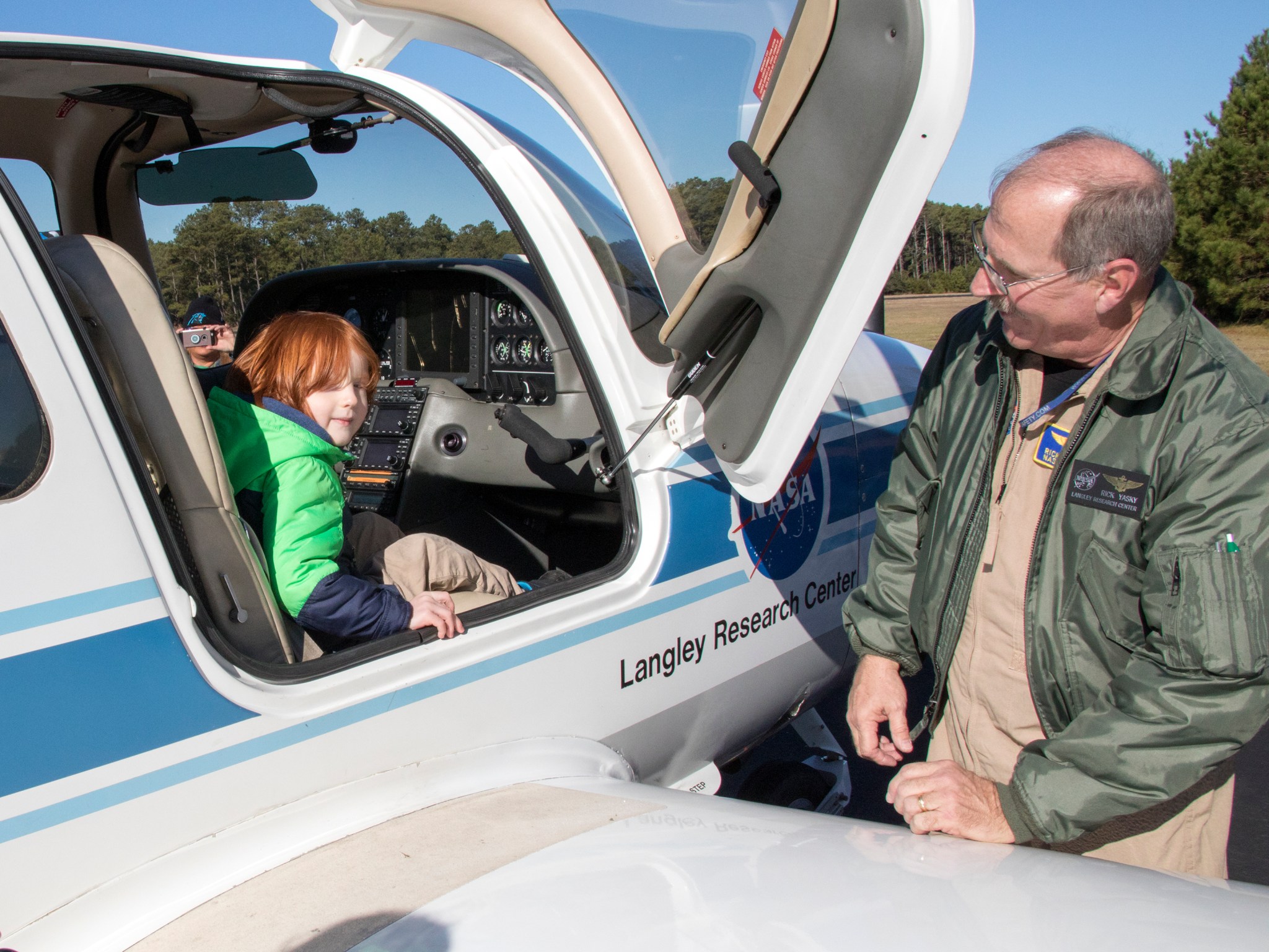 NASA Langley pilot Rick Lasky talks to a boy about the Cirrus SR-22 plane Monday after the ceremony.
