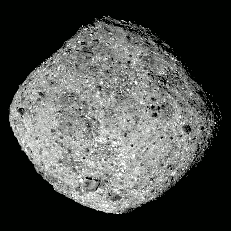 Gif of asteroid Bennu rotating against a black background. The asteroid is roughly diamond shaped and gray. It's covered with little rocks and boulders, giving it a lumpy appearance.
