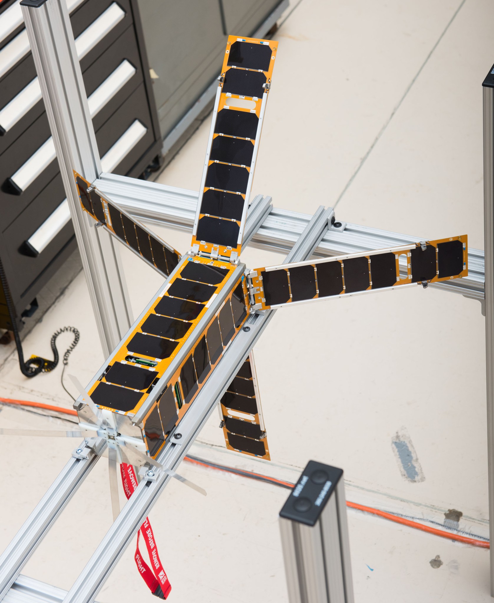 The ALBus CubeSat sits at NASA Glenn with its four solar array deployed. The solar arrays on this high-power CubeSat use a custo