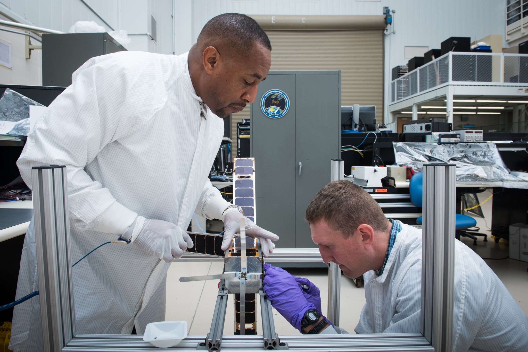 NASA Glenn engineers Mark Sorrells (left) and Allen Guzik (right) make final adjustments to the ALBus CubeSat before being shipp