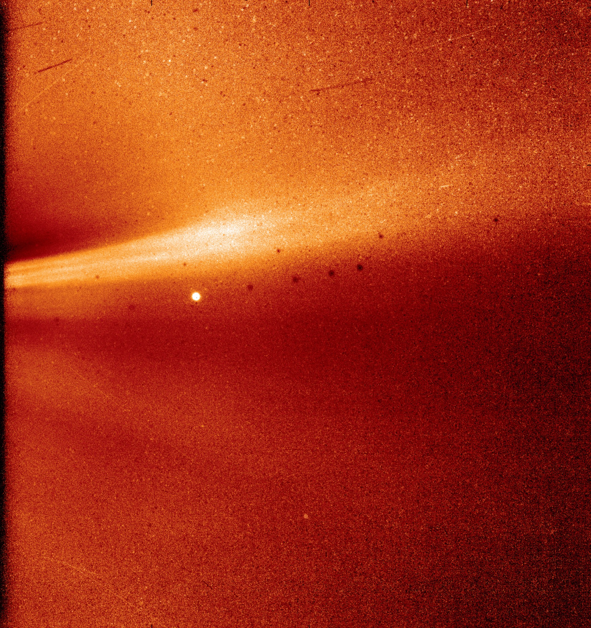 Parker Solar Probe image of coronal streamer. The image is dark orange, with a beam of lighter yellow streaking across it.