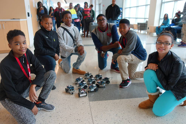 A group of students next to their race cars