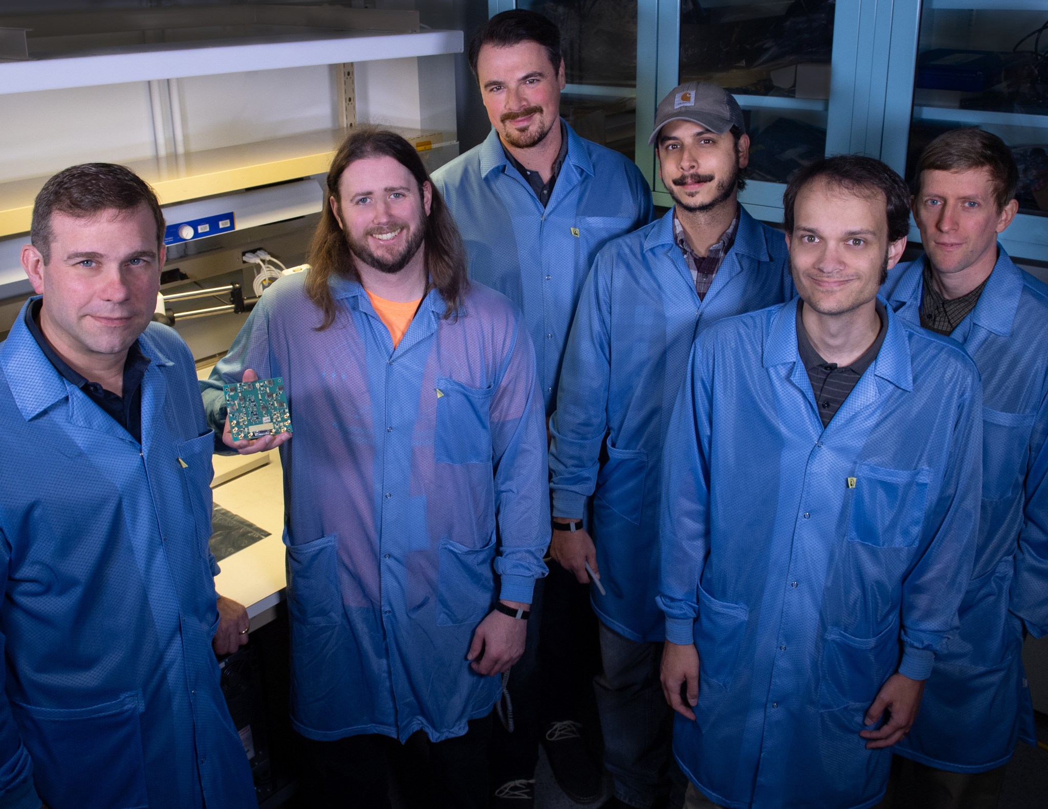 SNoOPI team, six men in blue lab coats