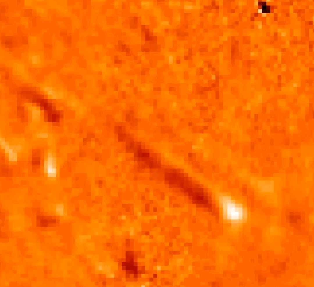 IRIS image of solar tadpole jet. Flashing images of the surface of the Sun, each colored a shade of orange or red, with a white arrow pointing to a pixelated bulbous bright light moving diagonally across the screen.