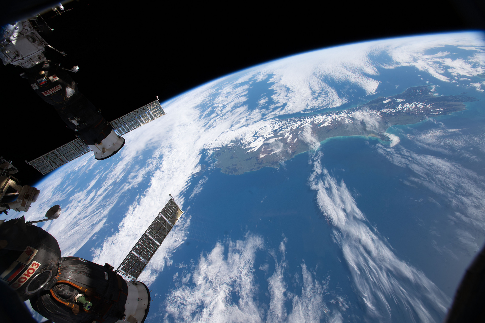 Two Russian spacecraft docked to the International Space Station, (bottom left) the Soyuz MS-09 crew ship and (top left)