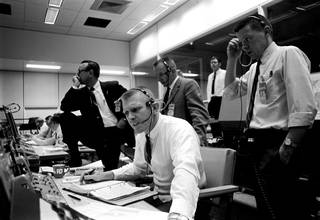 Lead Flight Director Kranz (seated) and managers and controllers monitor the Apollo 9 launch from Mission Control in Houston.