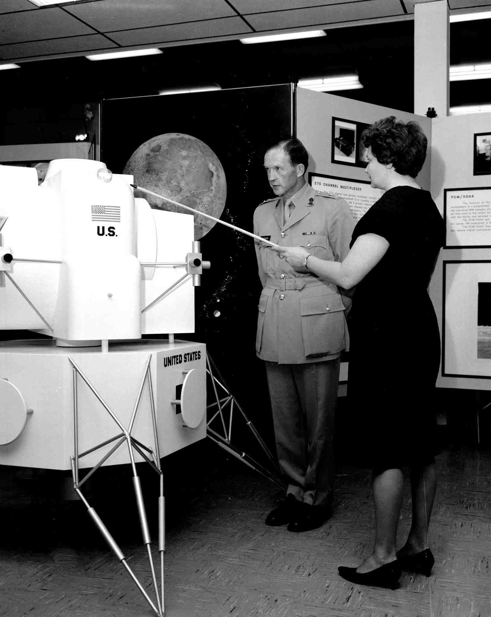 Evelyn Falkowski and British Colonel John Stevenson discussing space hardware exhibit at the Space Orientation Center.