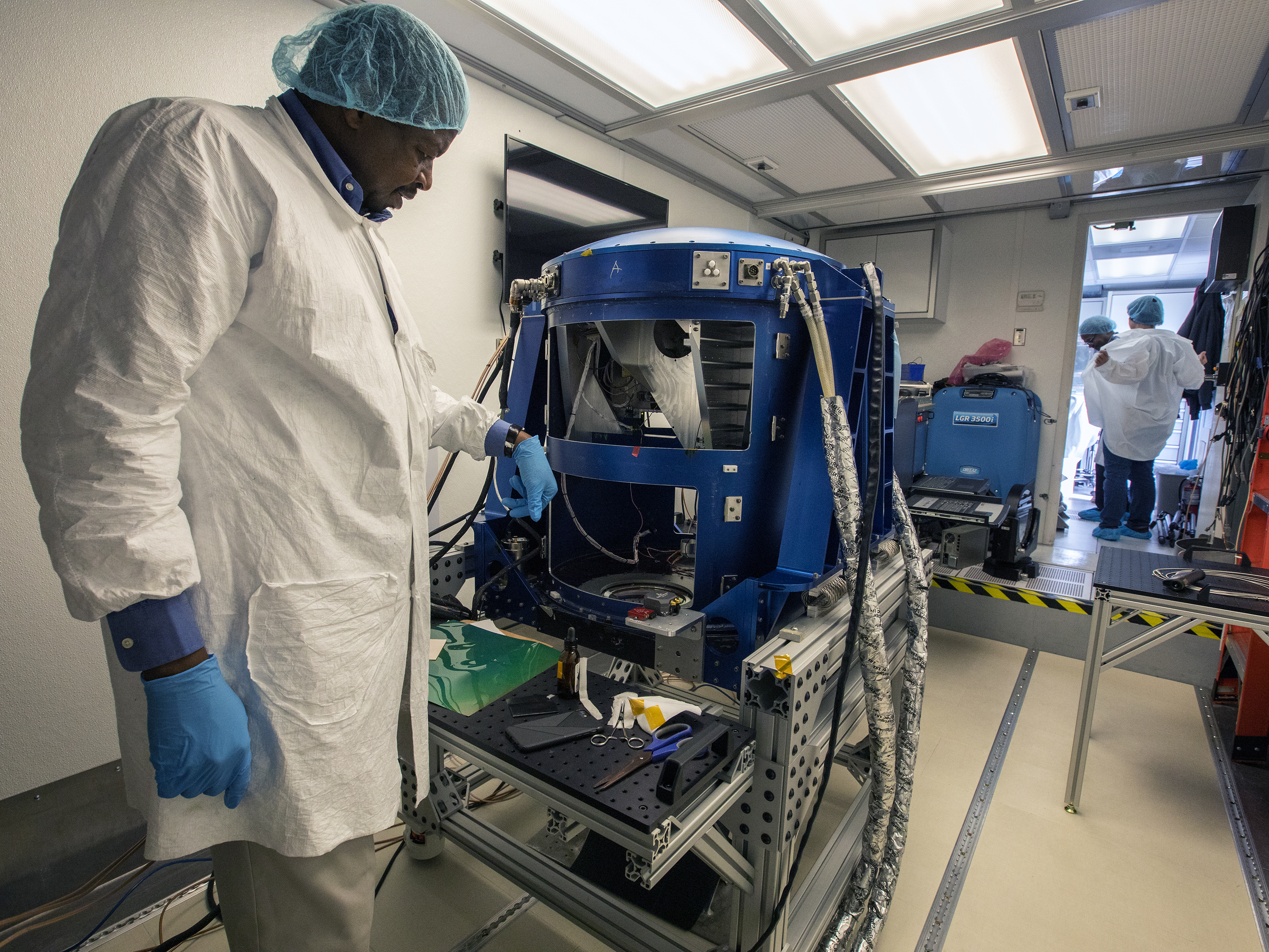 Optical Engineer Aboubakar Traore looks over the Doppler Aerosol Wind Lidar (DAWN)