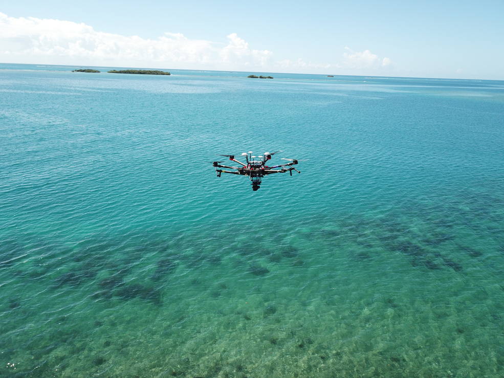 FluidCam instrument floating above a shallow and clear ocean.