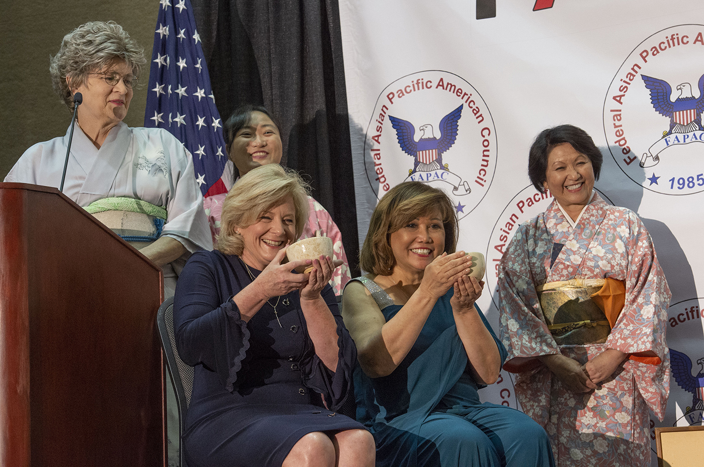 Jody Singer, seated left, participates in a traditional Japanese tea ceremony with FAPAC President Olivia Adrian, seated right.