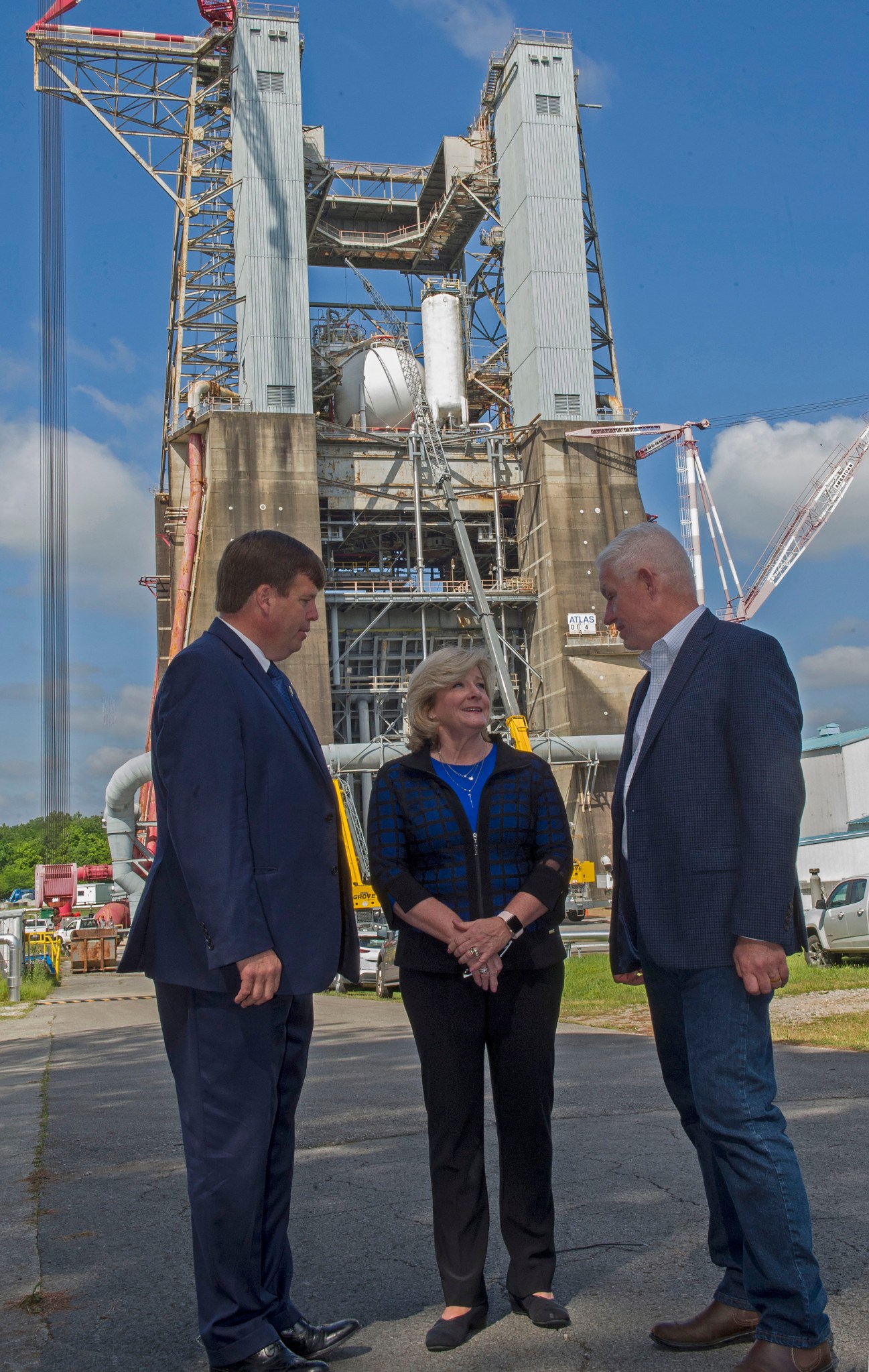 Jody Singer, center, and Dale Strong, left, meet with Terry Benedict, on May 20, in front of historic Test Stand 4670.