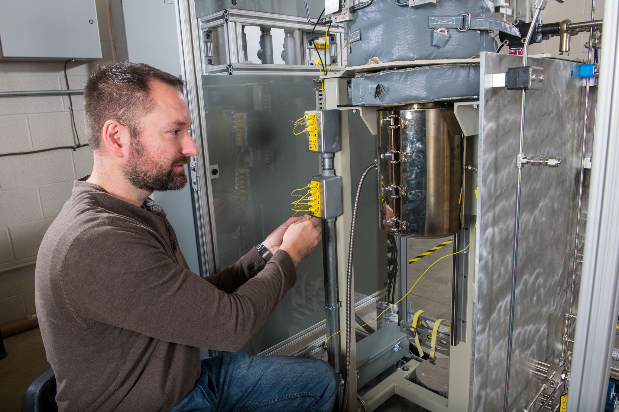 Man examining instrumentation channels before a test in the MiniGEER chamber.