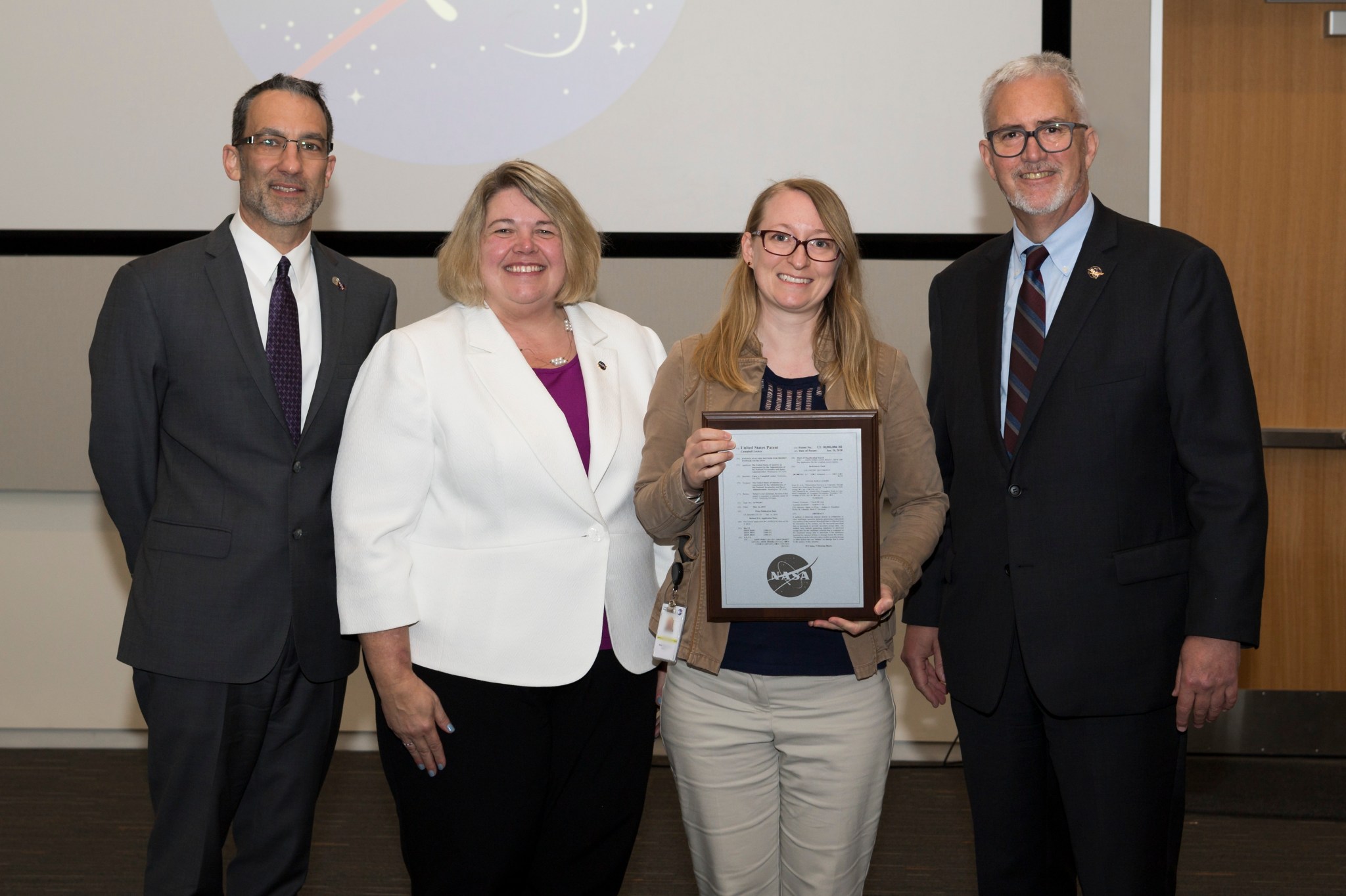 Cara Campbell Leckey, second right, is awarded a plaque for her patent on energy analysis method for hidden damage detection.