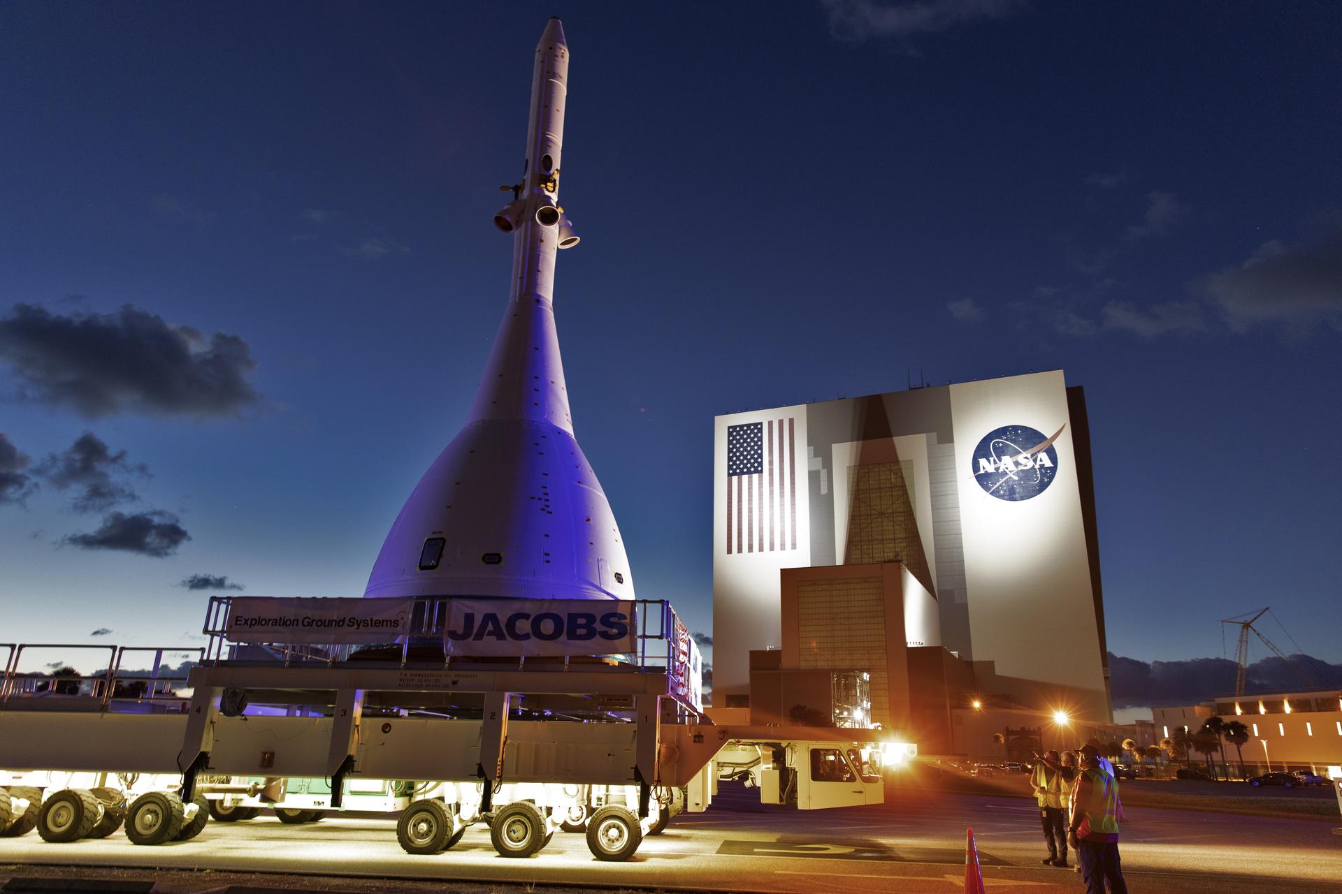 The test version of Orion attached to the Launch Abort System for AA-2 passes by the Vehicle Assembly Building.