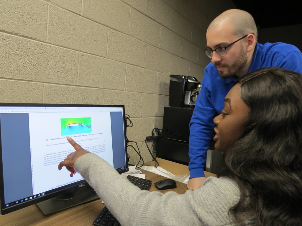 University of Tennessee students Arianna Worthy (front) and Hector Ortiz-Melendez discuss results