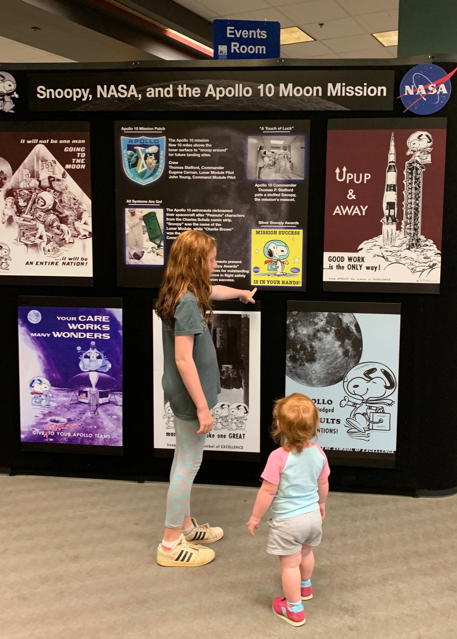 Marin Harbaugh, 11, left, and her 2-year-old sister Brynn visit the “Snoopy Soars With NASA” exhibit at the downtown library.
